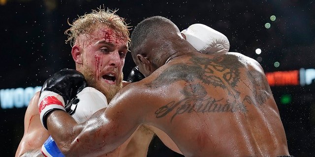 Jake Paul, left, punches Tyron Woodley during the third round of the Battle of Cruiserway on Sunday, December 19, 2021, in Tampa, Florida. 